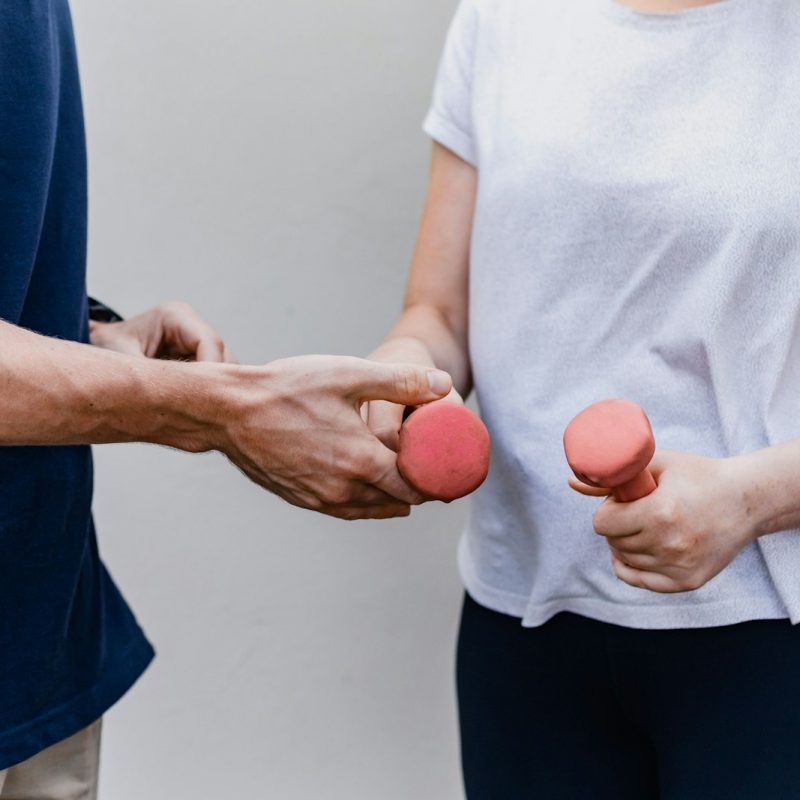a man and a woman holding dumbs in their hands